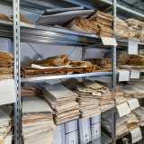 Lo ritroviamo interamente circondato da migliaia di documenti di ogni genere
